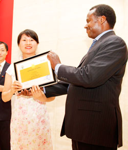 The PS, Ministry of Health.  Dr Uzziel Ndagijimana (R)  hands a certificate to Gaoyne Ming, one of the departing Chinese doctors. The New Times /Timothy Kisambira