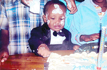 David tries to get his portion of cake. The New Times / Pelagie N. Mbabazi