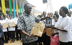  Premier Bernard Makuza hands over laptops to the best performing teachers during the Teachers' Day yesterday. The New Times John Mbanda.