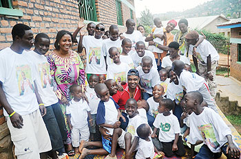 Scooper Knight (clad in red shirt) poses for a group photo with Mpore PEFA orphans. The New Times/John Mbanda.