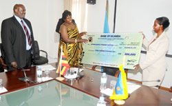  Minister Louise Mushikiwabo (R) receives a US$300,000 cheque from Ugandan minister Kabakumba Matsiko as Ugandan envoy to Rwanda Richard Kabonero looks on