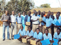 Some of the students, teachers and parents of Mukingi Secondary School pose with the coca-cola football trophy.