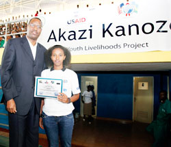 The Minister of Youth, Sports and Culture, Protais Mitali, posses for a picture with Noella Claudia Shimwa one of the graduates . The New Times / Timothy Kisambira.