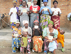 Some of the beneficiaries of the free health insurance with their cards . The New Times / B Mukombozi.