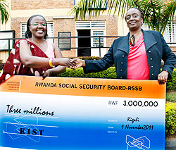 (L-R)KIST Rector Dr Jean du2019 Arc Mujawamariya receives a dummy cheque from Angelique Kantengwa the RSSB boss yesterday. The New Times / Timothy Kisambira.