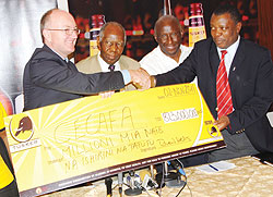 Serengeti Breweries Managing Director Richard Wells (R) hands over the cheque to Cecafa officials yesterday. The New Times/B. Mugabe.