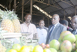 Central bank Governor, Claver Gatete (c), tours Kimironko market yesterday.The New Times / Dias Nyesiga.