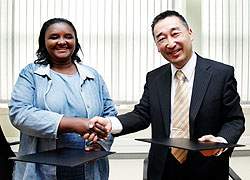 (R-L)Japanese Embassyu2019s Charge d'Affaires, Shigeru Kondo, exchanges documents with Rose Umulisa of Power of Love organisation yesterday. The New Times / Timothy Kisambira.