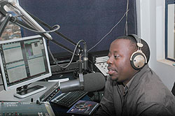 A broadcast journalist airs news in a radio studio. Government says it would woo  investors to the media industry. The New Times / File.