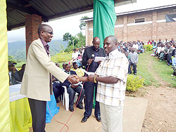 Everest Twahirwa, one of the beneficary farmers receives a Rwf1.3million cash award in Rutsiro District . The New Times / S. Nkurunziza