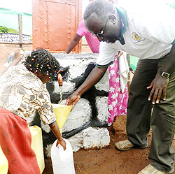  A Bank Populaire official guides a child to fill a container with tap water in Gituku village.The Sunday Times / S. Rwembeho