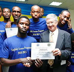  US Ambassador, Donald W. Koran, hands a certificate to Jean de Dieu Rwigema from APAPER Secondary School after completion of English course.The New Times / Timothy Kisambira.