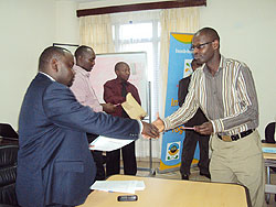  Kigali City Vice Mayor, Alphonse Nizeyimana (L),  hands a certificate to a trainee.The New Times / JP Bucyensenge.