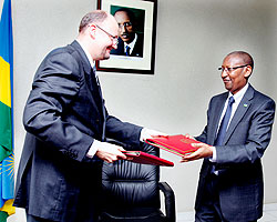 Ambassador Michel Arrion (L) exchanges documents with John Rwangombwa Minister of Finance yesterday. The New Times / Timothy Kisambira.