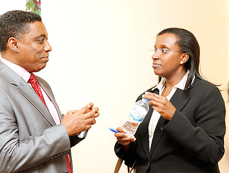 Desta Mebratu, Deputy Regional Director of UNEP (L) chats with Caroline Kayonga, PS in the Natural Resources ministry at the meeting yesterday. The New Times / T. Kisambira.