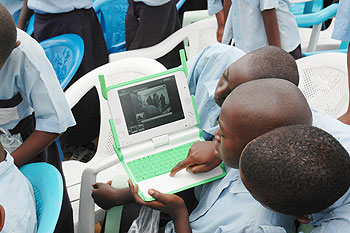 Kagugu Primary School boys try to take photographs with one of the Lap tops given to them. The New Times/J. Mbanda