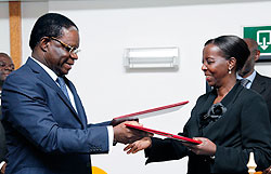 Basile Ikouebe (L), the Minister of Foreign affairs of Congo, exchanges documents with his Rwandan counterpart Louise Mushikiwabo after their meeting. The New Times / T. Kisambira