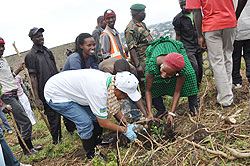 Dr. Rose Mukankomeje (L), Director General of REMA plants a tree with local residents yesterday in Rubavu.The New Times / Alex Ngarambe.
