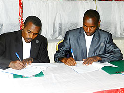 Rwamagana PSF chairman Jean Baptiste Murenzi (R) and Mayor Nehemie Uwimana sign pact. The New Times S. Rwembeho.