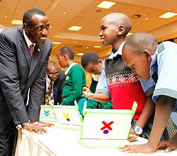 Senate president, Dr. Ntawukuliryayo listens to how  pupils use laptops for learning during the summit, yesterday.  The New Times / Timothy Kisambira.