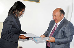 State Minister in charge of Energy and Water Emma Francoise Isumbingabo (L) and HAKAN Chairman Ahmet Karasoy exchange documents after the signing. The New Times / J. Mbanda.