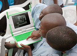 Primary School boys with a laptop. A pastor is being held in connection with theft of such laptops. The New Times / File.