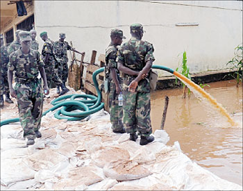RDF soldiers take part in an exercise to drain flood waters  in Nyabugogo  on Sunday. The New Times / File.
