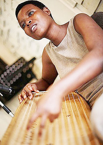 Sophie Nzayisenga playing the inanga, a traditional musical instrument in Rwanda.