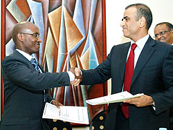 ICT Minister Dr Ignace Gatare (L), exchange documents with Sunil Bharti the managing director of Bharti Airtel as the latter formally entered the Rwandan market. The New Times / File.