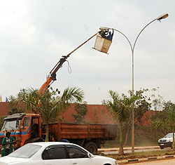Kigali City Council employees mount streetlights in Kigali City. The New Times / File.