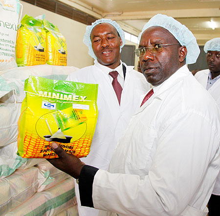 Prime Minister Habumuremyi  inspects maize flour manufactured by Minimex  during his tour of the plant yesterday. The New Times / T. Kisambira