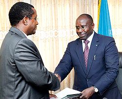 Dr. Vincent Biruta(L) minister of Education, receiving documents from Prime Minister Pierre Damien Habumuremyi.  The New Times / T. Kisambara.