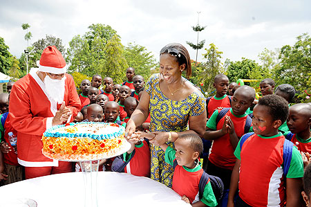 First Lady, Jeannette Kagame, helps a child cut the cake yesterday. The New Times / Courtesy