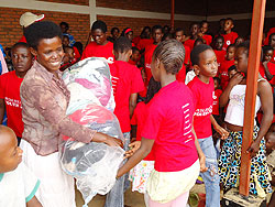 One of the beneficaries happily recieves her package .The New Times / G. Mugoya