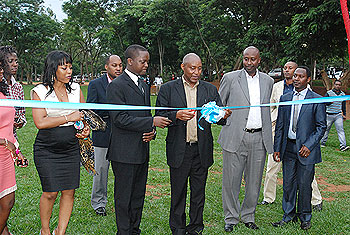 The former Headmaster of RIA Peter Claver Nkurunziza cuts the ribbon. Looking on are some of the OBs and OGs of RIA. The New Times/Courtesy photos.