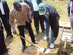 Minister Kamanzi uses a hand-brick-making machine. The New Times / J P Bucyensenge