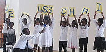 Children spell out JESUS CHRIST while explaining the meaning of each letter.
