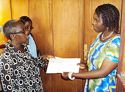 Josephine Uwamariya, ActionAid country director (left) hands over checque of the women's grant to Josephine Uwantege in charge of social affairs at Rwabicuma Sector. The New Times / Courtesy