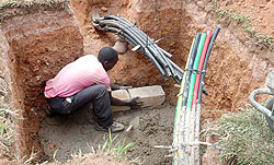 A Man lays Fibre Optic cables. The New Times / File