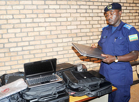 Police Spokesman Sup.Theos Badege examines the recovered laptops.  The New Times / J. Mbanda
