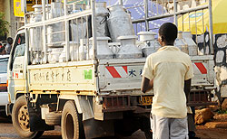 A boy loads milk cans. The New Times / File.