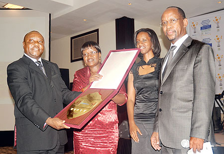 Serena Hotel Country Manager, Charles Muia (L) receives the Five-Start certification from the Minister for EAC affairs Monique Mukaruliza as RDBu2019s Rica Rwigamba (second L) and John Gara look on. The New Times/ J. Mbanda.