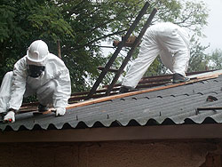 Removing asbestos requires proper clothing to avoid contamination. The New Times / Courtesy