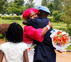 A police officer is welcomed from Haiti by a relative at the Police Headquarters in Kacyiru. The Sunday Times / T. Kisambira
