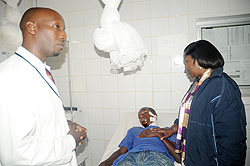 Health Minister Dr Agnes Binagwaho with one of the grenade explosion victims at Kibagabaga Hospital. Left is the Hospitalu2018s director Dr Christian Ntizimira. The New Times / J. Mbanda
