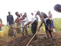 Rucagu (2nd R) joins members of Indagamirwa in preparing raw material for making bricks. The New Times / B. Kimenyi