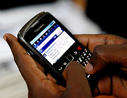 A tweep uses his Blackberry to share his views with the world. The New Times / T. Kisambira.