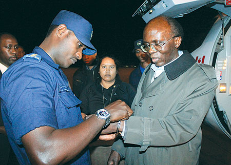 Lu00e9on Mugesera being handcuffed upon arrival at Kigali International Airport last night. The New Times / Timothy Kisambira.