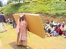 An elderly woman collects a mattress during an event organised to support the most vulnerable. The New Times/J.P Bucyensenge.