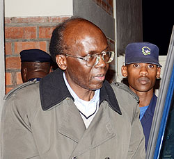 Leon Mugesera is led into a car upon his arrival ealier this week. This trial could take months before it commences. The New Times / file